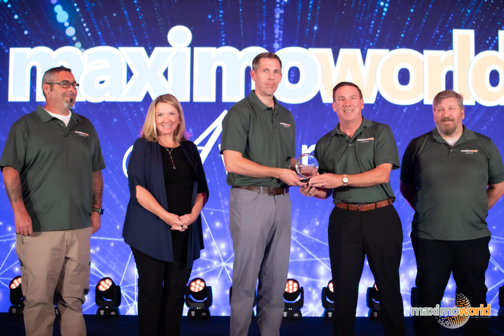 The Chugach Government Solution team receives the Best New Implementation award at MaximoWorld on August 9, 2022.